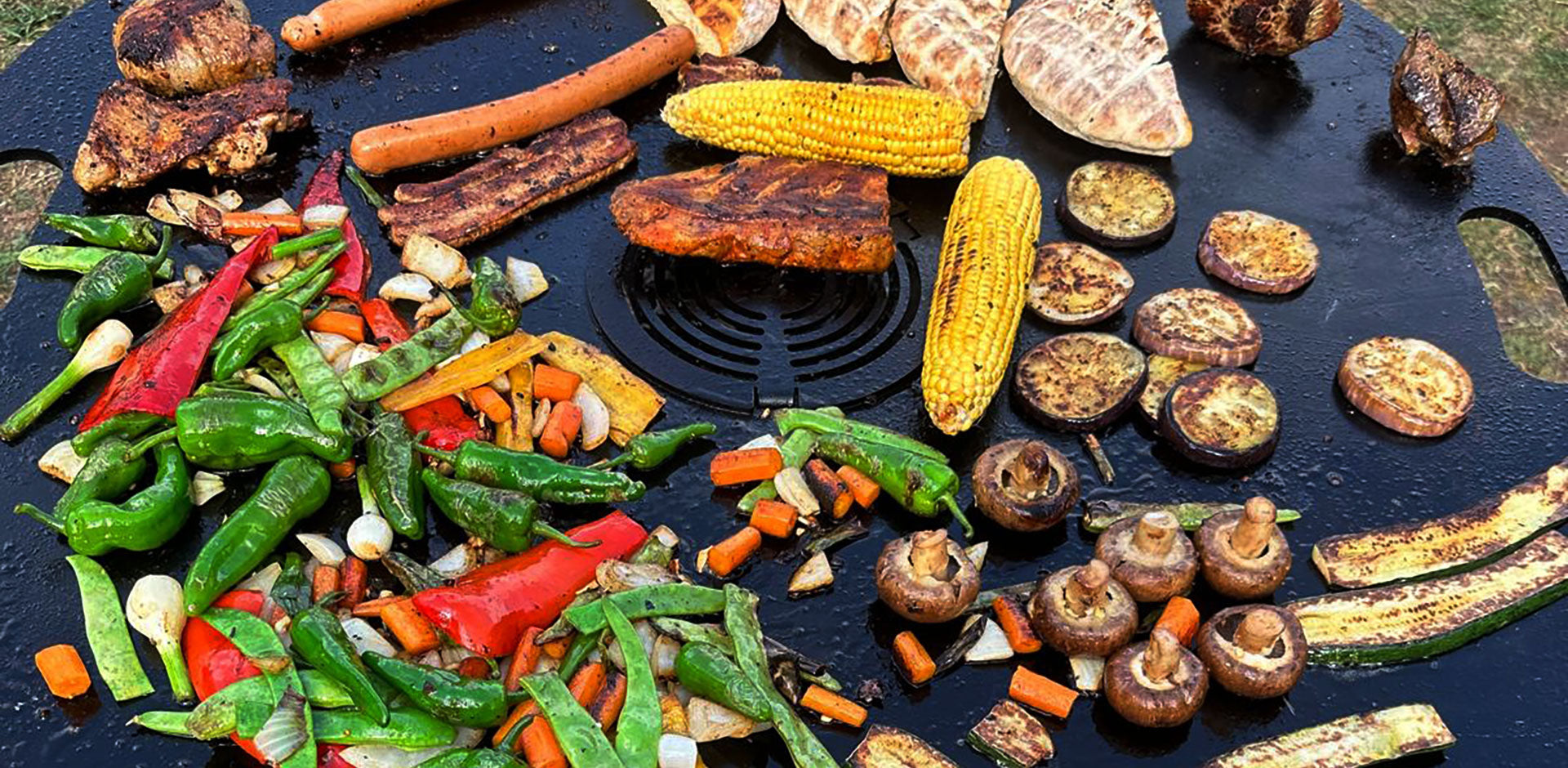 Feuerplatte mit Grilleinsatz im Einsatz für Grillgemüse, Fleisch und Outdoor-Cooking